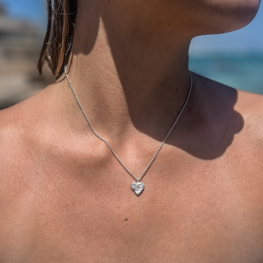 Ai no suna silver necklace on woman Silver necklace shaped as a sand grain heart on woman