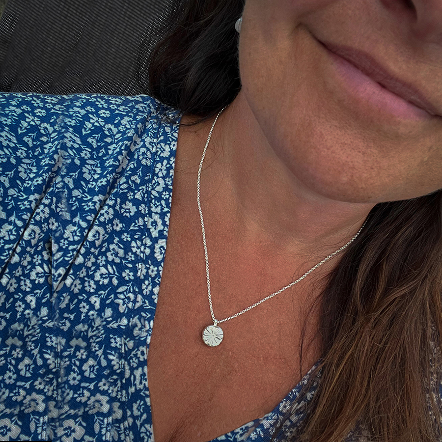 Grain of sand necklace close up on helena Silver necklace shaped after a grain of sand on woman close up