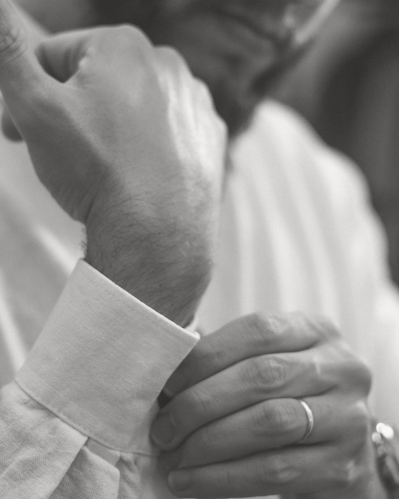 Man taking on cufflinks
